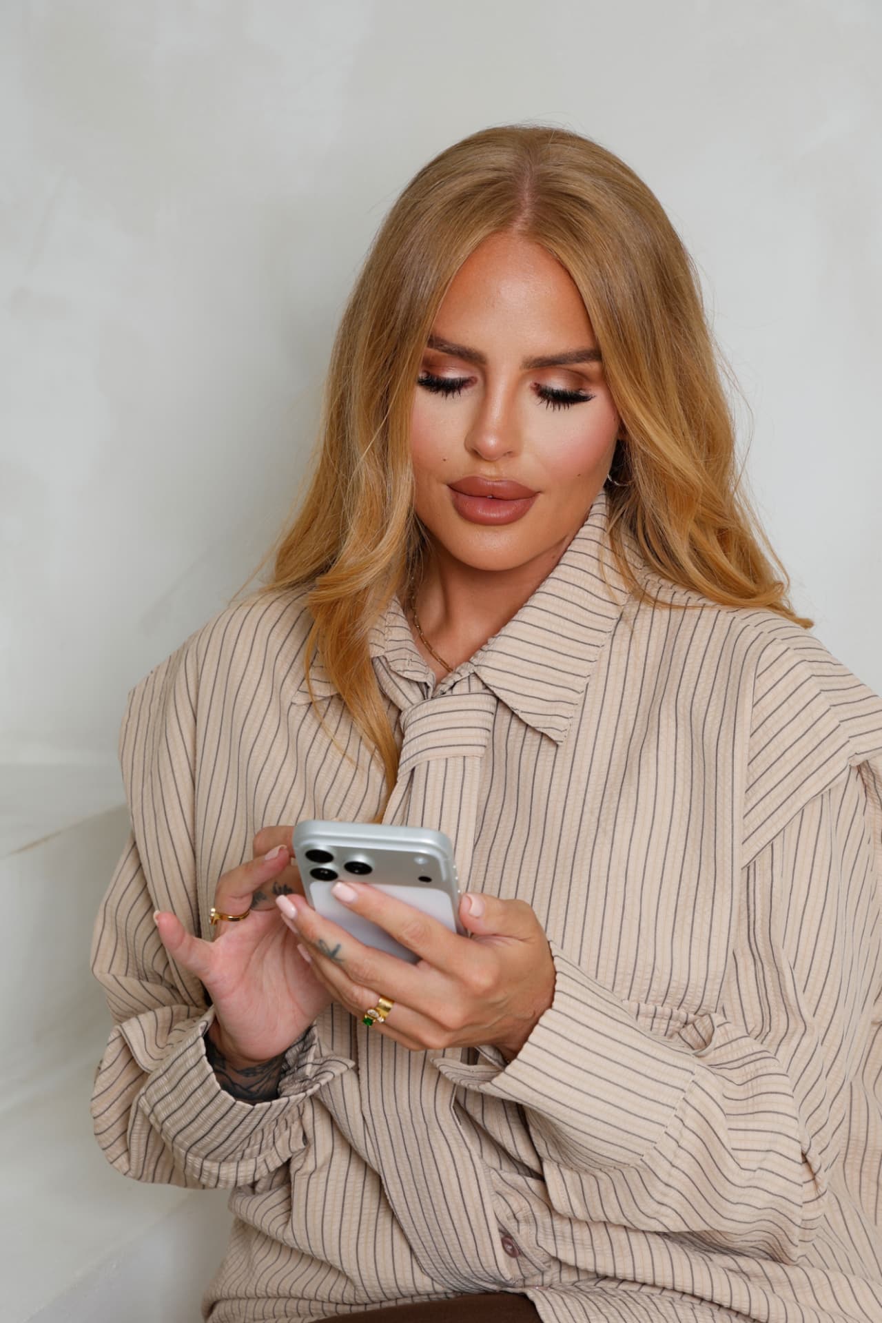 Sophia reading her phone in a striped shirt